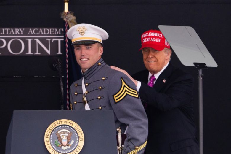 도널드 트럼프 대통령이 24일(현지시간) 미국 뉴욕 웨스트포인트에서 열린 미 육군사관학교 졸업식에서 육군 블랙나이츠의 미식축구 쿼터백인 졸업생 브라이슨 데일리의 등을 두드리며 격려하고 있다. AP 뉴시스