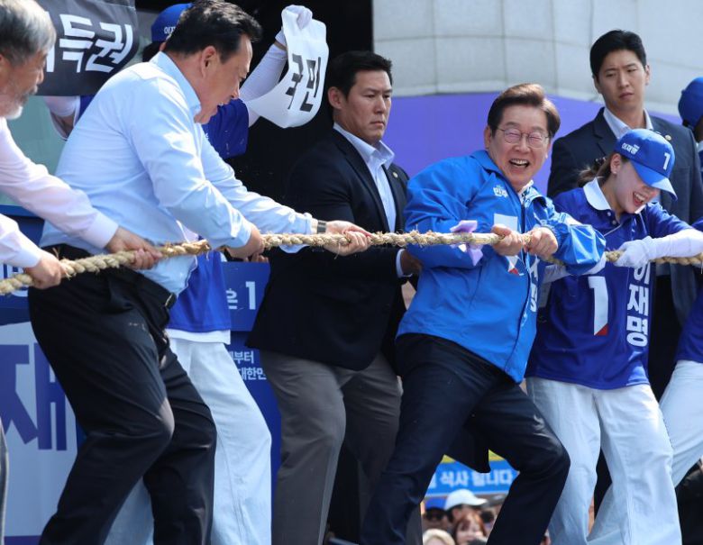 기득권과 줄다리기 벌이는 李 이재명 더불어민주당 대선 후보(오른쪽 두번째)가 25일 중원 공략에 나선 가운데 충남 당진시 당진전통시장에서 열린 유세에서 '국민편 대(對) 기득권편 줄다리기' 퍼포먼스를 하고 있다. 연합뉴스