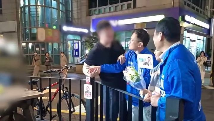 지난 23일 부산에서 더불어민주당 이재명 대선 후보 지원 유세를 하던 같은당 박주민 의원을 붙잡고 질문 중인 남성. 박주민TV 유튜브 캡처
