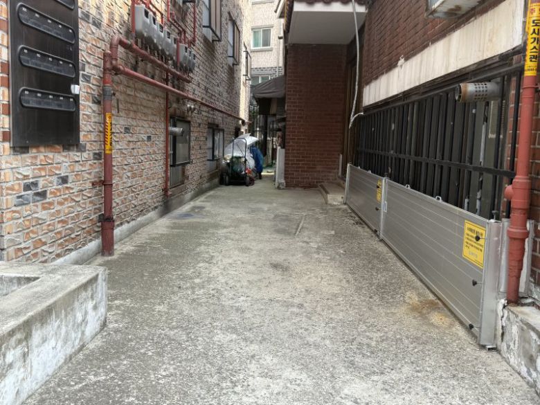 서울 동작구 상도역 2번 출구 인근 반지하 골목에서 물막이판이 설치된 건물(오른쪽)과 물막이판 없이 방범창만 설치된 건물(왼쪽)의 모습. 사진=이현정 기자