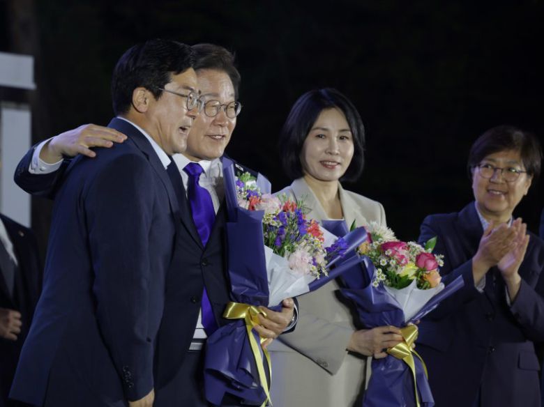 지상파 3사가 '당선 확실'을 보도한 직후 이재명 더불어민주당 대통령 후보가 4일 오전 서울 여의도 국회 앞에서 열린 국민 개표방송 행사에서 박찬대 상임선대위원장과 미소 짓고 있다. 이날 김혜경 여사는 첫 동행길에 나섰다. /사진=뉴스1