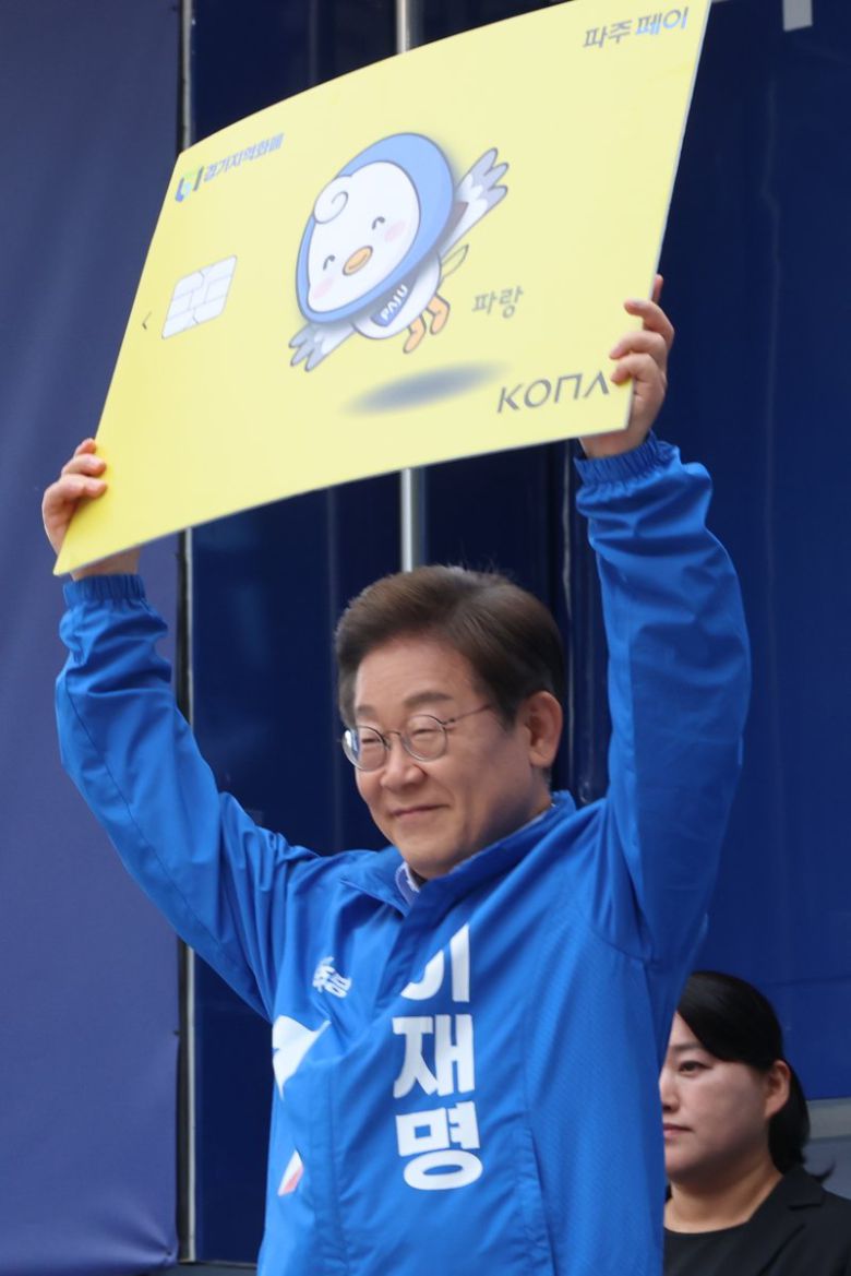 이재명 대통령이 지난 5월 20일 더불어민주당 대선 후보 당시 경기 파주시 금릉역 중앙광장에서 열린 유세에서 지역화폐 모형을 들어 보이고 있다. 연합뉴스