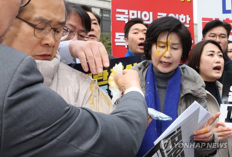 백혜련 더불어민주당 의원이 지난 3월 20일 서울 종로구 헌법재판소 앞에서 열린 민주당 원내부대표단의 윤석열 대통령 신속 파면 촉구 기자회견 도중 얼굴에 계란을 맞아 닦아내고 있다. /사진=연합뉴스