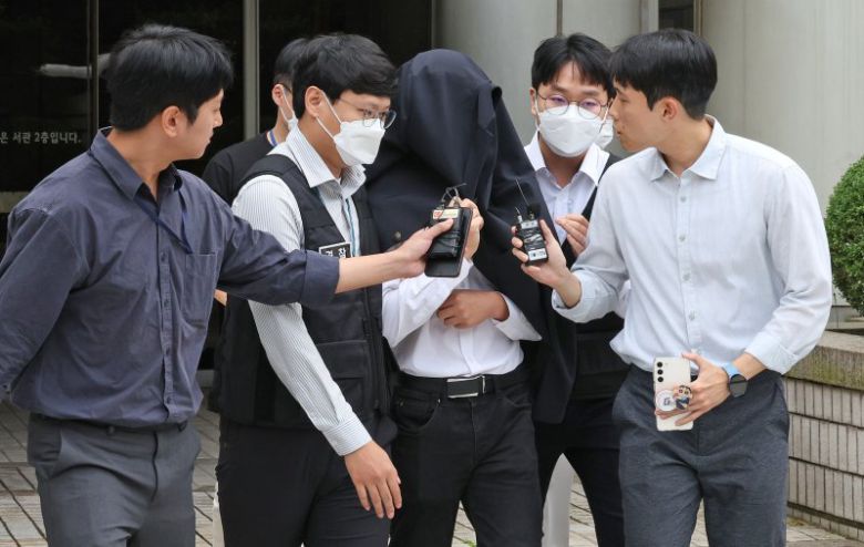 의료계 집단행동에 동참하지 않은 의사·의대생의 신상 정보가 담긴 블랙리스트를 유포한 사직 전공의 정모씨가 지난 2024년 9월 20일 서울 서초구 서울중앙지법에서 열린 구속 전 피의자 심문(영장실질심사)을 마친 뒤 경찰과 함께 이동하고 있다. /사진=뉴스1