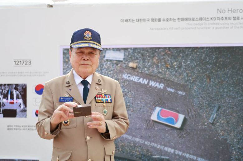 지난 12일 대전 한화생명볼파크에서 열린 한화 방산 3사 국가유공자 초청 야구관람 행사에 참석한 대한민국 월남전참전자회 대전광역시지부장 정병무 국가유공자가 K9 자주포의 철을 활용한 태극기 배지를 들고 기념촬영을 하고 있다. 한화에어로스페이스 제공