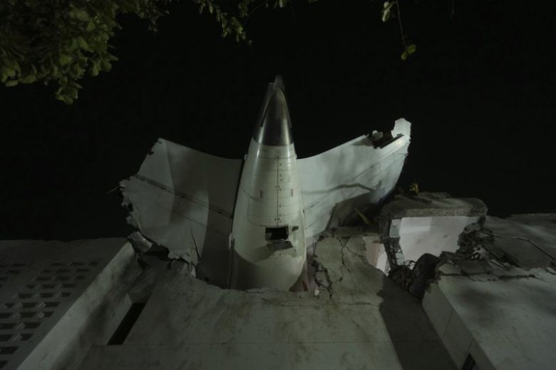 12일(현지 시간) 인도 구자라트주 아마다바드에서 발생한 여객기 추락 사고 현장에 비행기 꼬리 부분이 건물에 박혀 있다. 뉴시