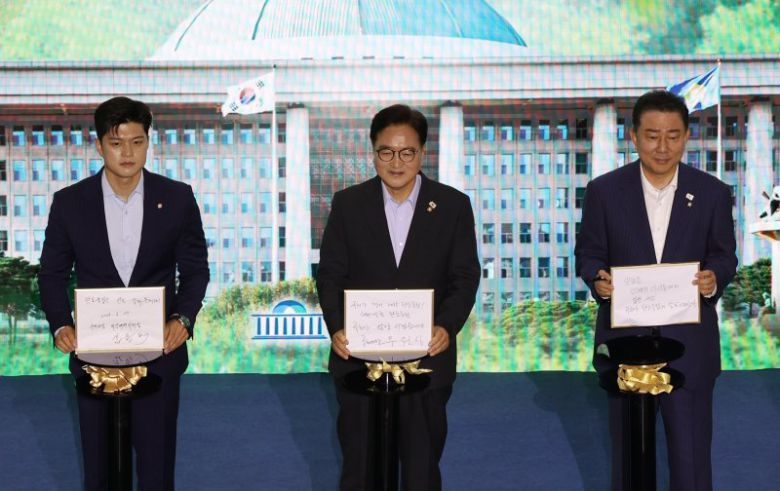 우원식 국회의장(가운데)이 17일 서울 여의도 국회에서 열린 탄소중립 선언식에서 김병기 더불어민주당 대표 직무대행 겸 원내대표(오른쪽), 김용태 국민의힘 비상대책위원장과 함께 탄소중립 비전 퍼포먼스를 하고 있다. 뉴시스