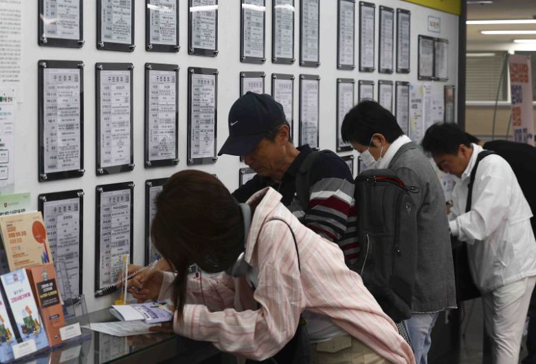 지난달 14일 서울 마포구 서부고용복지플러스센터 일자리 정보 게시판 앞에서 구직자들이 이력서를 작성하고 있다. 뉴시스