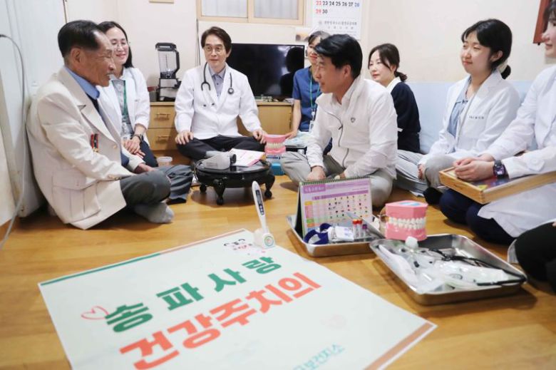 서강석 송파구청장(앞줄 가운데)이 지난 17일 '호국 보훈의 달 국가 유공자 방문 의료서비스'를 계기로 서울 송파구 국가유공자 황병준 씨의 집을 방문해 대화하고 있다. 송파구 제공