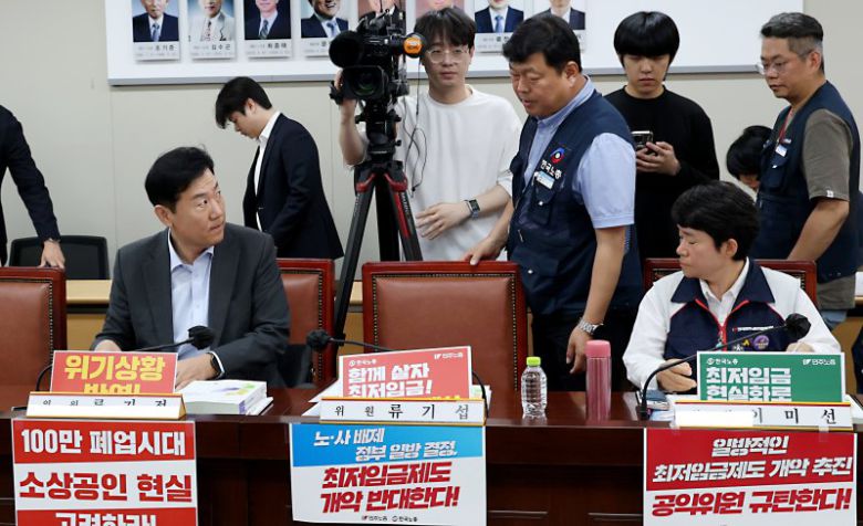 19일 세종시 정부세종청사에서 열린 최저임금위원회 제6차 전원회의에 참석한 류기정 사용자위원(왼쪽)과 류기섭 근로자위원이 회의에 참석하며 이야기를 나누고 있다. 뉴스1