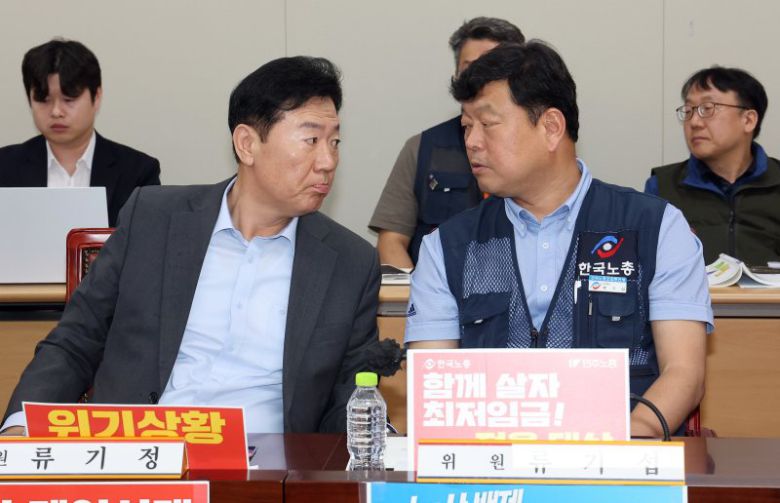 최저임금위원회 사용자위원 간사인 류기정 한국경영자총협회 전무(왼쪽)와 근로자위원 간사인 류기섭 한국노총 사무총장이 19일 정부세종청사에서 열린 최저임금위원회 제6차 전원회의에서 나란히 앉아 얘기를 나누고 있다. 연합뉴스