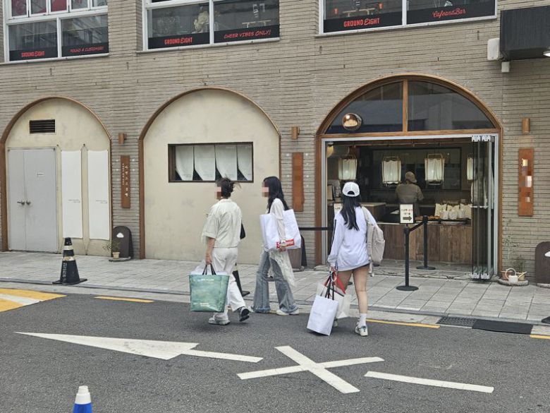 지난 24일 서울 강남구 압구정 일대에서 의류잡화 브랜드 쇼핑백을 든 청년들이 지나가고 있다. 사진=최가영 기자