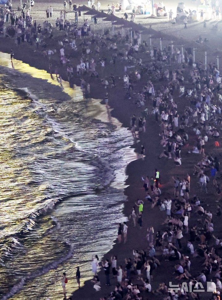 올 여름 부산지역에 지난해보다 19일이나 빨리 열대야가 찾아온 가운데 부산 광안리해수욕장을 찾은 시민과 관광객들이 더위를 식히고 있다. 뉴시스