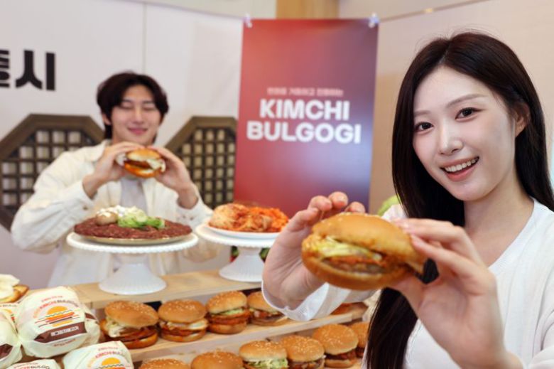 3일 서울 용산구 롯데리아 숙대입구역점에서 열린 신제품 버거 출시행사에서 모델들이 신메뉴 '김치불고기버거' 2종을 소개하고 있다.