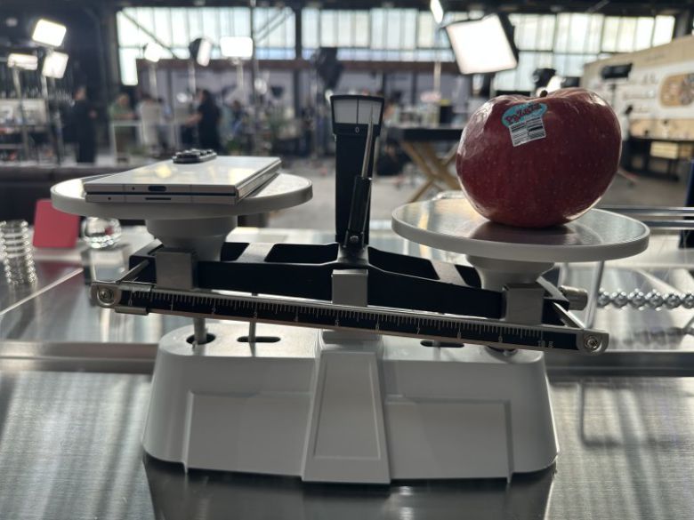 갤럭시 Z 폴드7(왼쪽)과 사과의 무게를 저울에 올려 비교해보고 있다. 사진=홍창기 기자