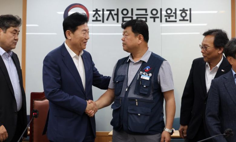 10일 밤 세종시 정부세종청사에서 열린 최저임금위원회 전원회의에서 2026년도 적용 최저임금이 1만 320원으로 결정됐다. 회의가 끝난 후 류기정 사용자 위원과 류기섭 근로자 위원이 악수하고 있다. 이날 민주노총은 공익위원이 제시한 심의촉진구간에 반발, 집단 퇴장했다. /사진=뉴시스화상