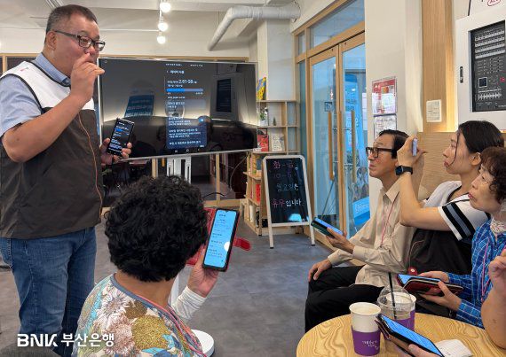 BNK부산은행이 지난 12일 부산 영도구 와치종합사회복지관에서 어르신 10여명을 대상으로 ‘시니어 스마트폰 교육 봉사활동’을 실시했다. BNK부산은행 제공