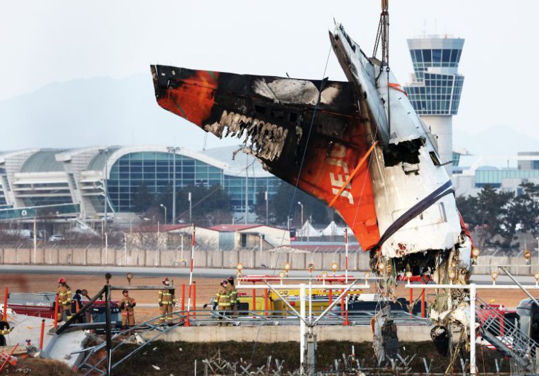 전남 무안국제공항 참사 현장에서 제주항공 7C2216편 사고 기체의 꼬리 부분이 크레인에 의해 인양되고 있다. 뉴스1