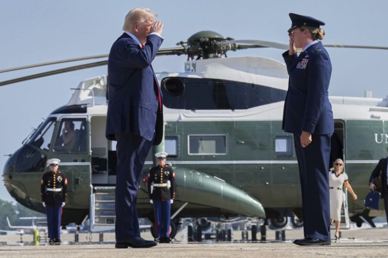 도널드 트럼프 미국 대통령이 25일(현지시간) 메릴랜드주 앤드루스 합동기지에서 스코틀랜드로 향하는 에어포스원에 탑승하기 직전 멜리사 돔브록 공군 제89비행단 부사령관의 안내를 받으며 경례하고 있다. AP연합뉴스