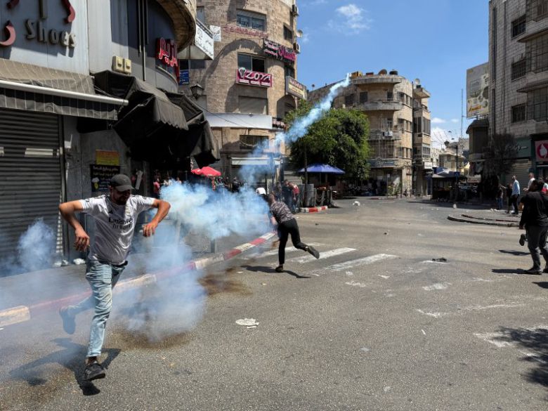 지난달 26일(현지시간) 팔레스타인 서안지구 라말라에서 현지 주민들이 이스라엘군의 최루탄을 주워 다시 던지고 있다.로이터연합뉴스