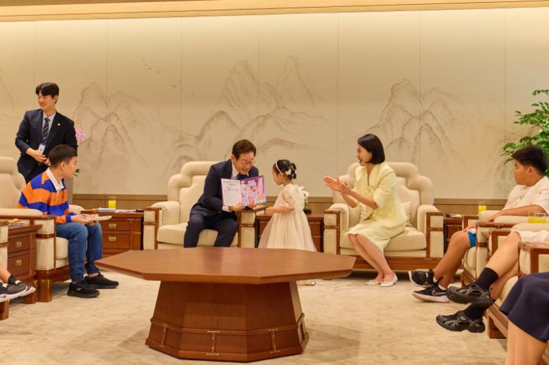 이재명 대통령이 지난 4일 서울 용산 대통령실 청사에서 열린 어린이 초청 행사에서 참석자에게 사인이 담긴 책을 선물하고 있다. 뉴스1