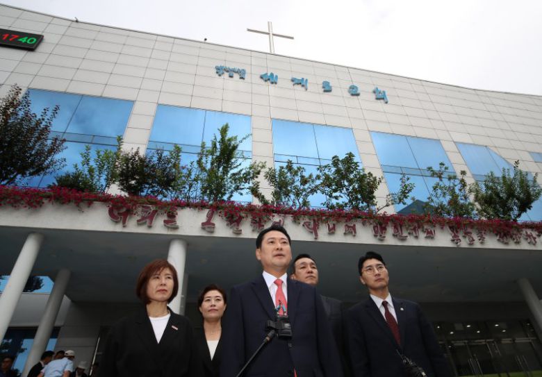 장동혁 국민의힘 대표(왼쪽 세번째)가 14일 경찰에 최근 구속된 손현보 목사가 담임 목사로 있는 부산 강서구 세계로교회 예배에 참석하며 취재진 질문에 답하고 있다.뉴스1