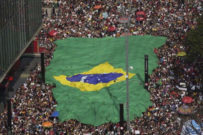 21일(현지시간) 브라질 상파울루에서 자이르 보우소나루 전 브라질 대통령과 그의 측근을 사면할 수 있는 법안에 항의하는 시위대가 대형 국기를 들고 있다.AP뉴시스