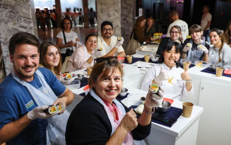 29일(현지시간) 스페인 마드리드 아르테스 예술센터에서 열린 ‘2025 스페인 K-박람회’에서 한국농수산식품유통공사 ‘K-FOOD’ 부스 한식 쿠킹클래스 김밥 아틀리에에 참가한 현지인들이 김예림 셰프와 함께 만든 김밥을 들어 보이고 있다. 사진가 우채연 제공. 뉴스1