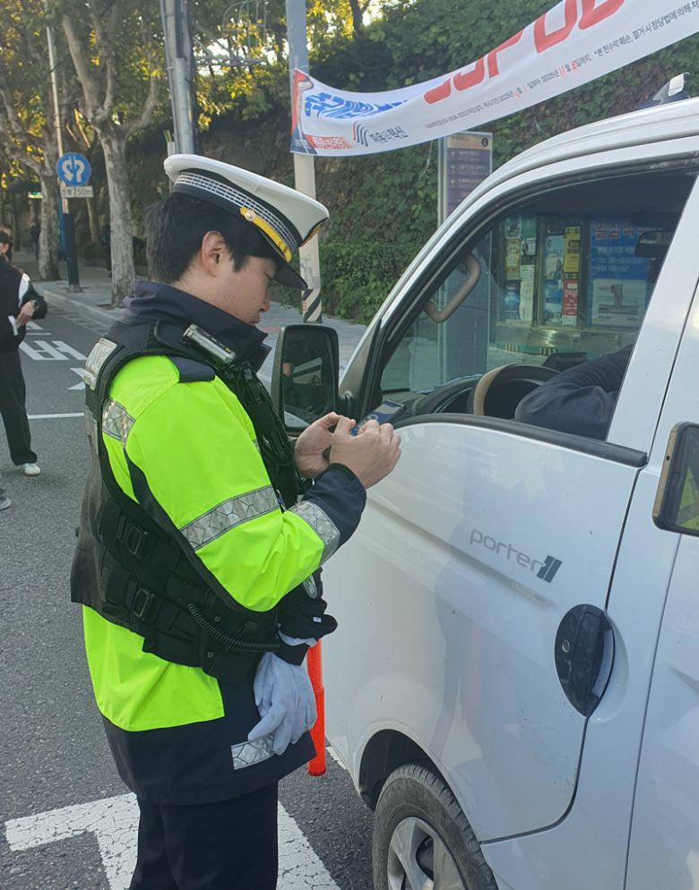 4일 오전 연세대학교 정문 앞 삼거리에서 경찰관이 꼬리물기 차량 운전자의 신분증을 확인하고 있다. 사진=최승한 기자