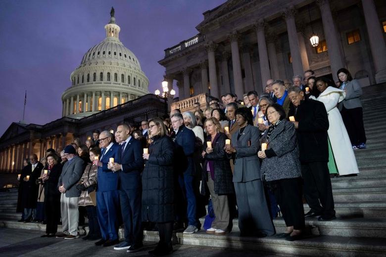 미국 하원의 민주당 인사들이 6일(현지시간) 미국 워싱턴DC 국회의사당에 앞에서 지난 2021년 1월 6일 발생한 의회 폭동 희생자를 추모하는 촛불을 들고 있다.AFP연합뉴스