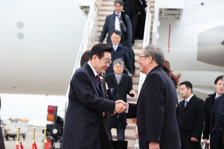 한일 정상회담을 위해 일본을 방문한 이재명 대통령이 13일 오사카 간사이 국제공항에 도착해 환영 인사들과 인사하고 있다. 뉴시스
