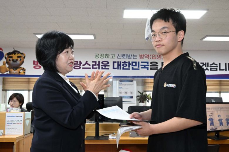 홍소영 병무청장이 15일 오전 서울 영등포구 서울지방병무청 제1병역판정검사장에서 열린 2026년도 병역판정검사에서 첫 현역 판정자를 축하해주고 있다. 공동취재단