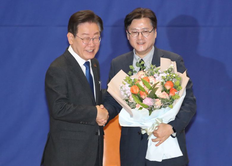 이재명 대통령이 더불어민주당 대표 당시 서울 여의도 국회 의원회관에서 열린 '제22대 국회 더불어민주당 제1기 원내대표 선출 당선자 총회'에서 임기를 마친 홍익표 전 원내대표에게 꽃다발을 전달하고 있다. 뉴스1