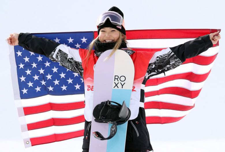중국 허베이성 장자커우의 겐팅 스노우파크에서 열린 스노보드 여자 하프파이프 경기가 끝난 뒤 열린 플라워 세리머니에서 금메달을 차지한 미국 클로이 김이 성조기를 들고 기뻐하고 있다.뉴시스