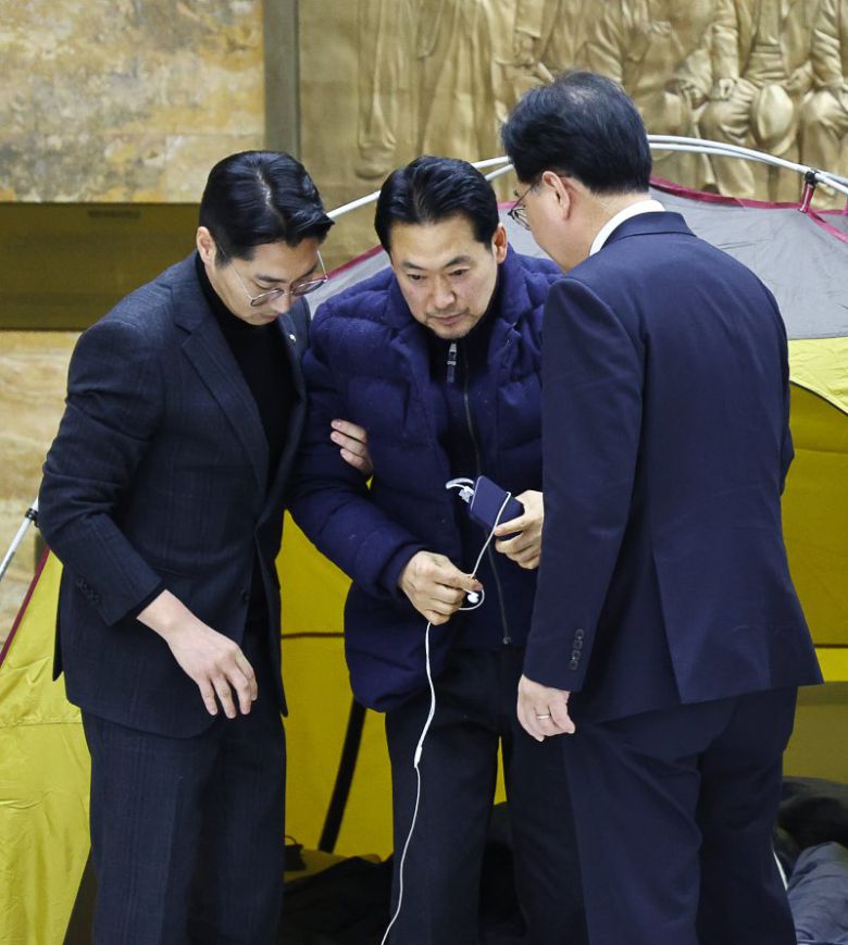 통일교·공천헌금 '쌍특검'을 요구하며 닷새째 단식을 진행 중인 장동혁 국민의힘 대표가 19일 오후 서울 여의도 국회 로텐더홀에서 송언석 원내대표와 박준태 당대표 비서실장의 부축을 받으며 이동하고 있다. 뉴시스