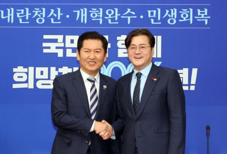 더불어민주당 정청래 대표가 21일 국회에서 취임 인사차 방문한 홍익표 청와대 정무수석을 만나 악수하고 있다. 연합뉴스