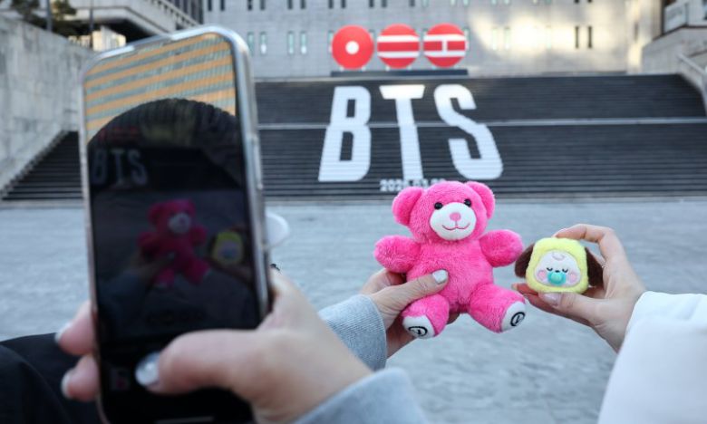 22일 오후 서울 종로구 세종문화회관 계단에 설치된 방탄소년단(BTS)의 정규 5집 컴백을 알리는 홍보물을 배경으로 관광객들이 기념촬영을 하고 있다. 뉴스1