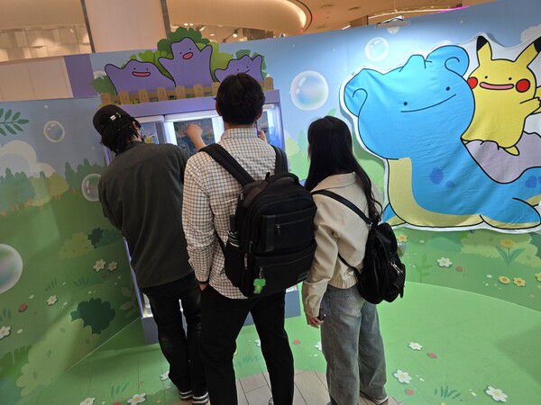 - 줄 서서 캡슐 토이로 굿즈를 구매하려는 방문객들