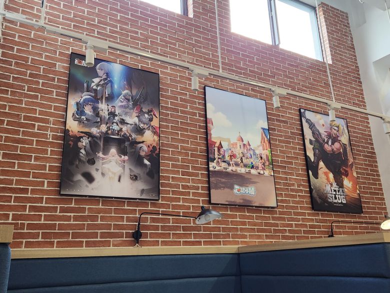 - 벽면에는 서비스 중인 자사의 게임 포스터가 붙어 있다