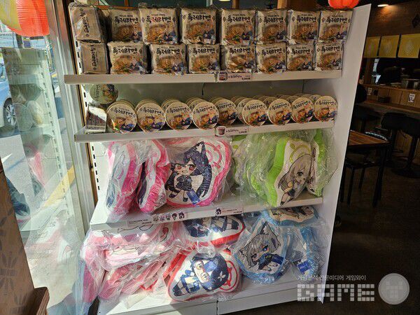 식사후 구매할 수 있는 굿즈들의 모습. 쿠션, 봉지라면, 컵라면을 구매할 수 있다 / 게임와이 촬영