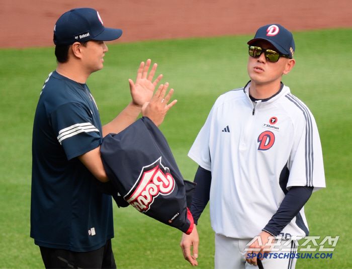 투수들의 훈련을 지켜보던 박정배 투수코치가 이영하와 대화하고 있다.