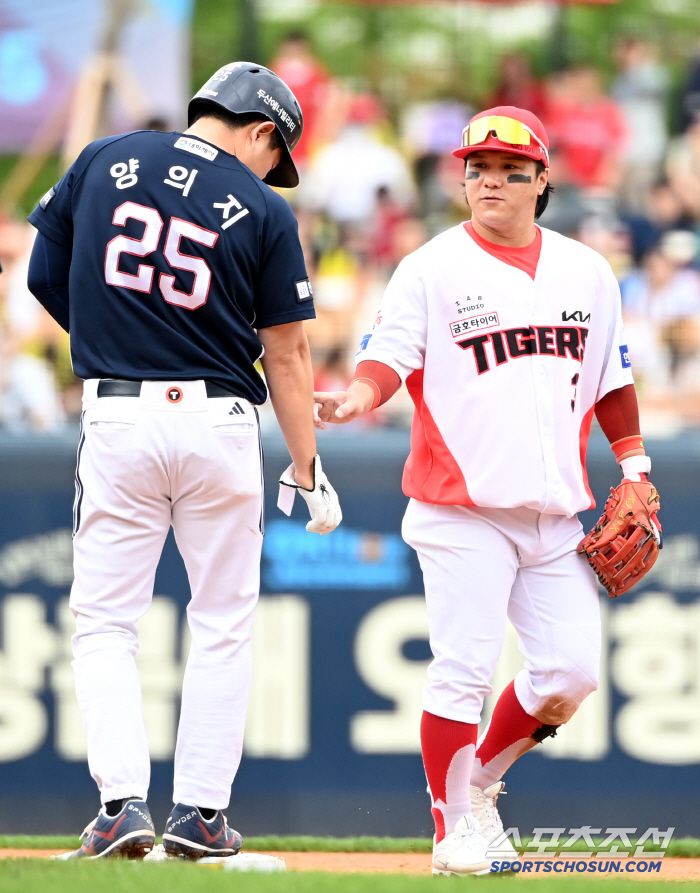 양의지의 아픈 오른팔을 손가락으로 건드리는 김선빈