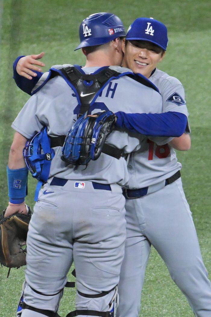 야마모토 요시노부가 완투로 5대1 승리를 이끈 뒤 포수 윌 스미스와 포옹하고 있다. EPA연합뉴스