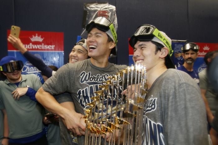 Oct 31, 2025; Toronto, Ontario, CAN; Los Angeles Dodgers two-way player Shohei Ohtani (17) and pitcher Yoshinobu Yamamoto (18) and pitcher Roki Sasaki (11) celebrate with the Commissioner's Trophy in the clubhouse after defeating the Toronto Blue Jays in the 2025 MLB World Series at Rogers Centre. Mandatory Credit: John E. Sokolowski-Imagn Images        <저작권자(c) 연합뉴스, 무단 전재-재배포, AI 학습 및 활용 금지>