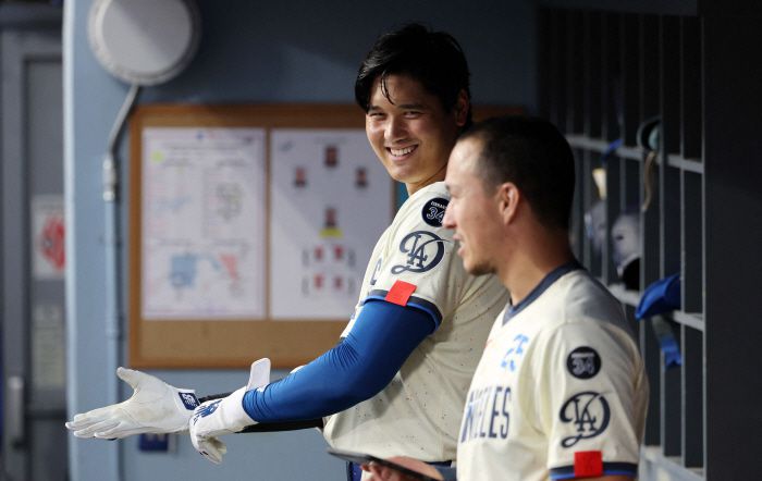 LOS ANGELES, CALIFORNIA - SEPTEMBER 20: Shohei Ohtani #17 of the Los Angeles Dodgers talks with Tommy Edman #25 in the dugout as they prepare to face pitcher Kai-Wei Teng #66 of the San Francisco Giants during the third inning at Dodger Stadium on September 20, 2025 in Los Angeles, California.   Kevork Djansezian/Getty Images/AFP (Photo by KEVORK DJANSEZIAN / GETTY IMAGES NORTH AMERICA / Getty Images via AFP)        <저작권자(c) 연합뉴스, 무단 전재-재배포, AI 학습 및 활용 금지>