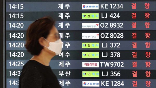 최대 풍속 초속 43m 강풍을 동반한 제8호 태풍 `바비`의 영향으로 26일 제주공항의 463편 전 노선을 비롯해 전국의 항공기 운항이 큰 차질을 빚었다. 한 시민이 모든 노선의 결항을 알리는 김포공항 내 안내판 앞을 지나가고 있다. [이충우 기자]