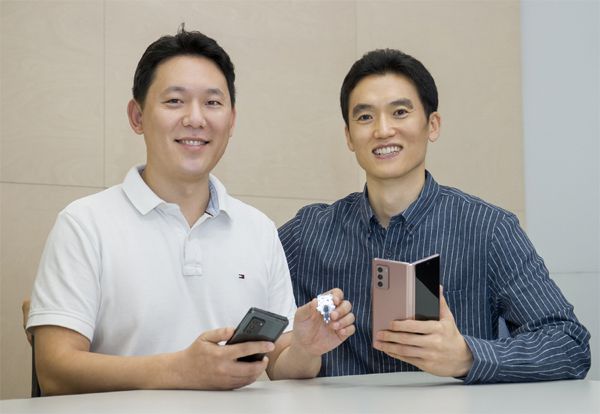 삼성전자 무선사업부 기구개발팀의 황승현 프로(왼쪽)와 문희철 프로가 핵심 기술이 담긴 힌지 부품과 갤럭시 Z 폴드2를 들고 있는 모습. [사진 제공 = 삼성전자]