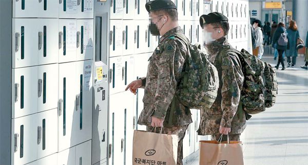 26일 오전 서울역에서 군 장병들이 열차를 타기에 앞서 물품 보관함에서 물건을 찾고 있다. 국방부는 코로나19 확산을 감안해 다음달 7일까지 군 내부에서 거리 두기를 2.5단계로 격상하고 모든 장병의 휴가와 외출을 통제한다고 밝혔다.  [한주형 기자]