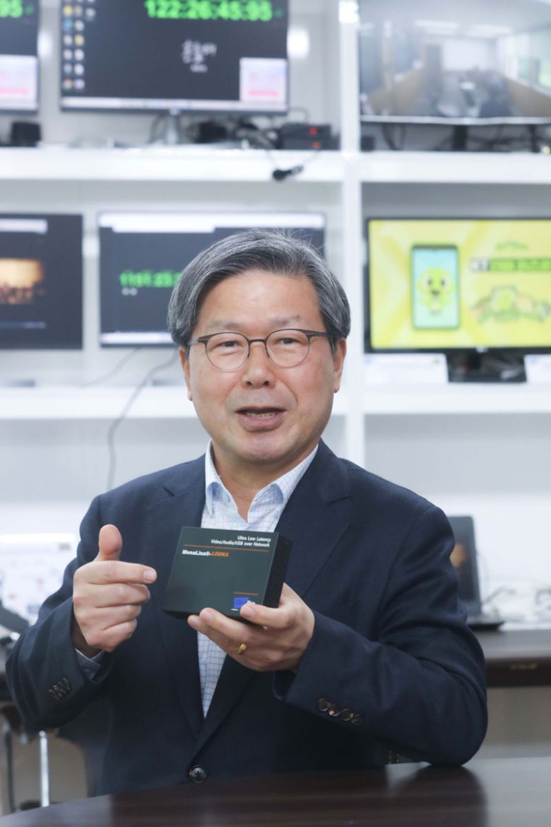 이상훈 쿠오핀 대표가 초저지연 영상 전송 반도체가 들어간 전용 기기를 들고 포즈를 취하고 있다. 원격 영상전송 기술을 보유한 쿠오핀은 다음달 4K UHD 영상을 실시간으로 전송할 수 있는 시스템 반도체 `모나리자3`를 출시할 예정이다.  <사진제공=LG유플러스>