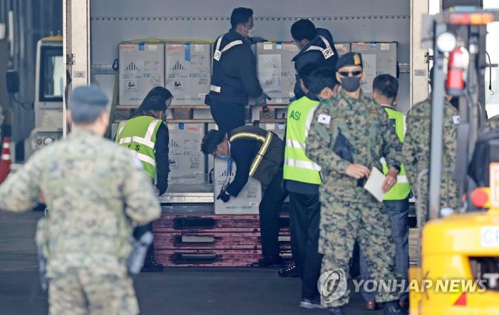 지난 21일 인천국제공항 화물터미널에서 관계자들이 정부가 화이자와 직접 계약한 백신 25만 회분(12만5000명분)을 옮기고 있다. [사진 = 연합뉴스]